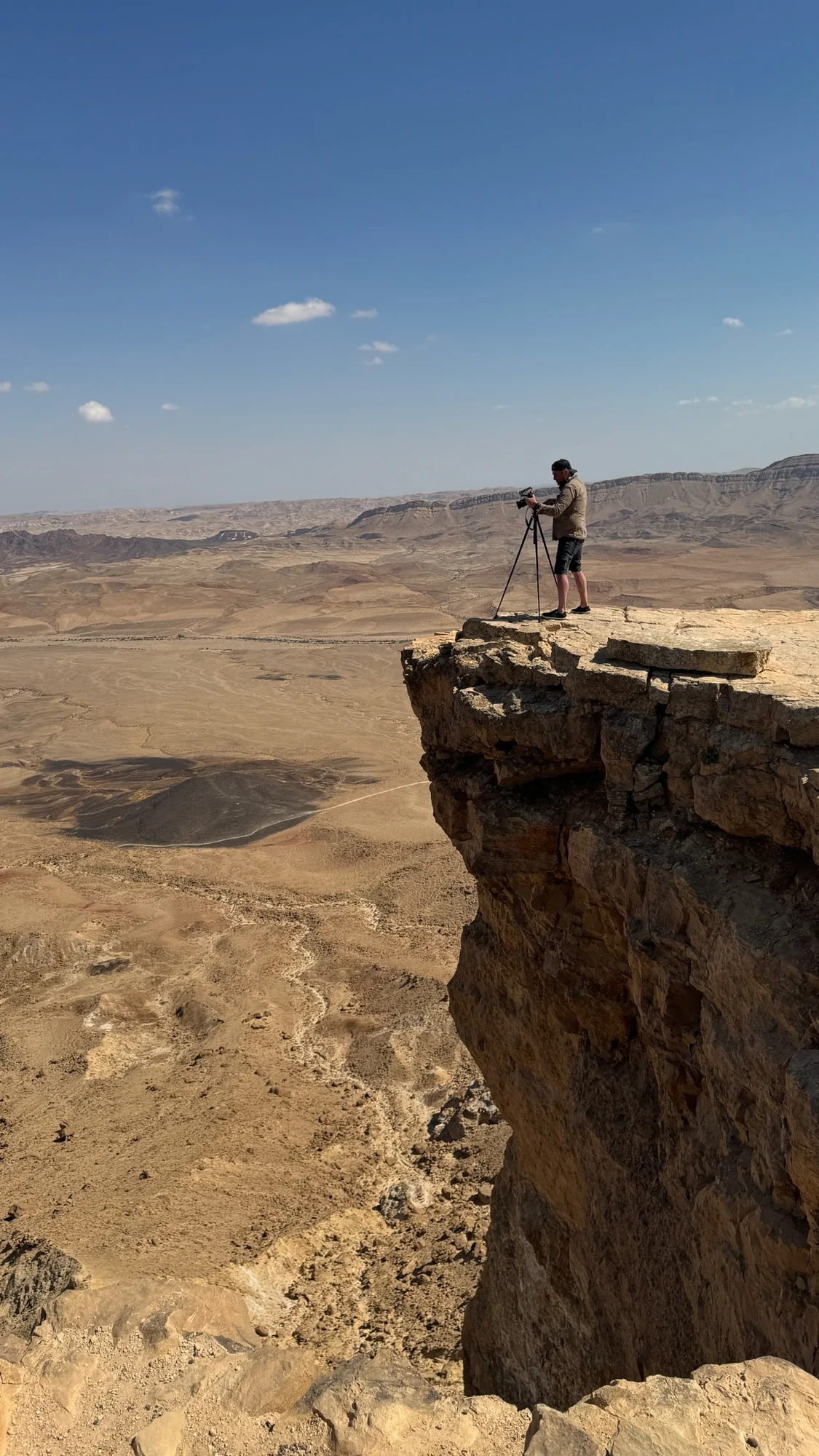Chris Atkins filming from a desert cliff